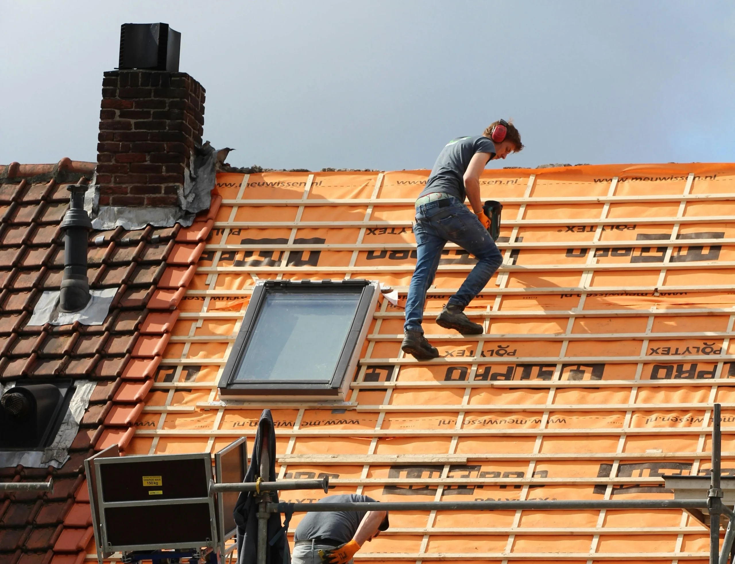image of two males working on a roof